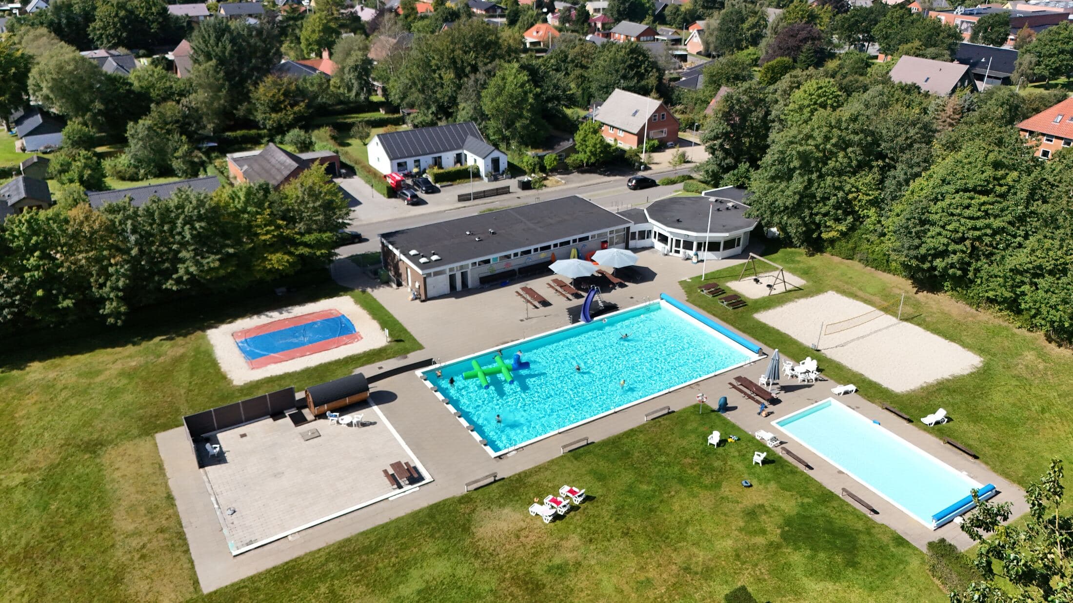 Luftfoto af Bording Friluftsbad med bassiner og faciliteter set fra oven